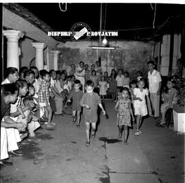 Anak-anak sedang mengikuti lomba kelereng di sebuah perkampungan dalam malam peringatan HUT Kemer...