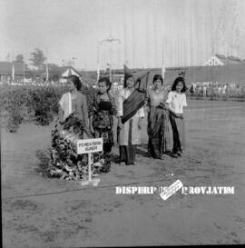 Para remaja putri dengan berpakaian adat  bersiap-siap dengan karangan bunga dalam upacara pering...