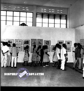 Suasana dalam ruang galeri pameran, para pengunjung sedang menikmati lukisan dan Grafika tentang ...