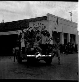 Beberapa arek-arek Suroboyo sedang menaiki sebuah jeep yang menggambarkan drama teatrikal perobek...