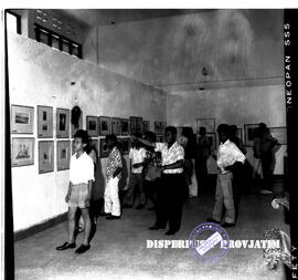 Suasana dalam ruang galeri pameran, para pengunjung sedang menikmati lukisan dan Grafika tentang ...
