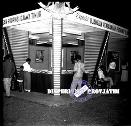 Suasana stand pameran milik Djawatan Penerangan pada malam hari pada Pekan Raya Surabaya ke – 33,...