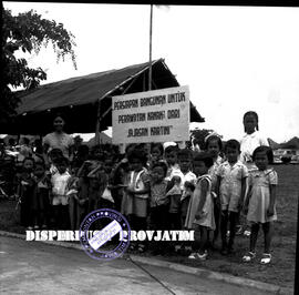 Anak-anak foto bersama di depan papan tulisan rencana pembangunan gedung perawatan kanak-kanak ya...