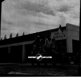Beberapa arek-arek Suroboyo sedang menaiki sebuah jeep yang menggambarkan drama teatrikal perobek...